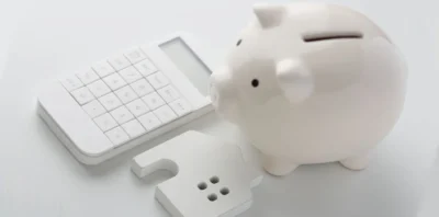 a white piggy bank and a calculator